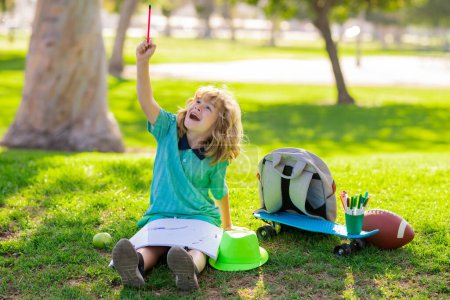 Photo for Child play and draw craft artwork homework. Kid boy create artist paints, summer vacation. School child drawing in summer park, painting art. Little painter draw pictures outdoor - Royalty Free Image