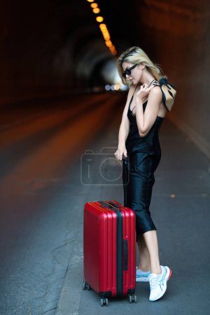 Téléchargez les photos : Voyage et aventure. Voyageur femme touristique en robe de mode avec valise. Sexy girl avec sac de voyage prêt à voyager en vacances - en image libre de droit