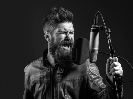Photo for Expressive singer with microphone. Handsome man in recording studio. Music performance vocal. Singer singing song with a microphone - Royalty Free Image