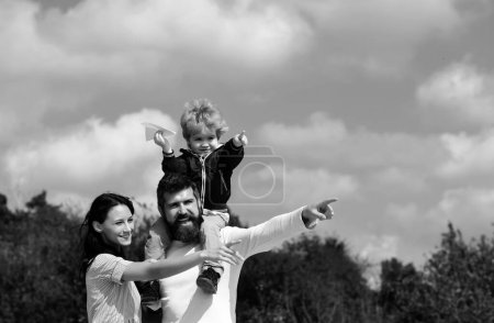 Photo for Child playing with toy airplane and dreaming future, concept of dreams and travels. Happy family portrait having fun together with toy paper plane. Father mother and child son - Royalty Free Image
