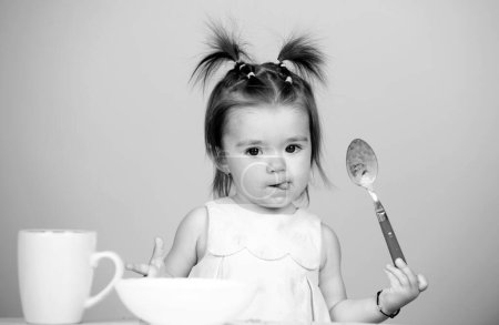 Photo for Kid eat healthy nutrition, baby food. Babies eating with spoon. Funny baby girl with spoon on studio, isolated - Royalty Free Image
