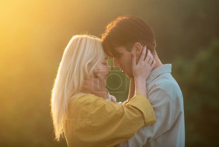 Photo for Sensual lovers hugging and kissing at sunset. Sensual portrait of young couple in love. Loving couple embracing and kissing - Royalty Free Image