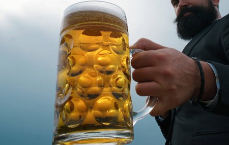 Foto de Enfoque selectivo de la mano con vaso de cerveza. Tazas de cerveza - Imagen libre de derechos