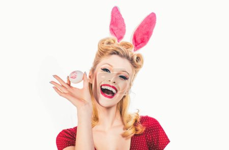 Foto de Una mujer encantadora disfrazada de conejo. Una mujer encantadora disfrazada de conejo. Cazando huevos. Chica bonita caza huevos de Pascua. Dulce chica adorable en orejas de conejo celebrando la Pascua - Imagen libre de derechos