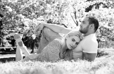 Téléchargez les photos : Jeune couple amoureux. Deux personnes se relaxant dans des fleurs de sakura. Mari et femme relation amoureuse - en image libre de droit