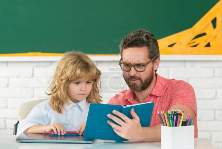 Photo for Kid boy learning with teacher. Funny little boy study with father in class on blackboard. Child from elementary school. Teacher and little student portrait, teachers day - Royalty Free Image
