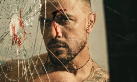 Destroy obstacles. Handsome brutal man near broken glass. Brutal handsome macho focused on fight result. Concentrated on target. Want to fight right now. Fight concept. Man muscular body punching.