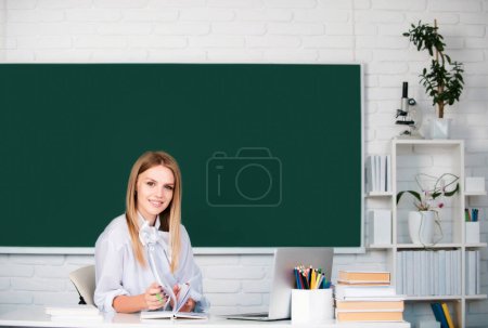 Photo for Smiling girl or teacher portrait on blackboard background. Student preparing exam and learning lessons in school classroom. Student education concept - Royalty Free Image