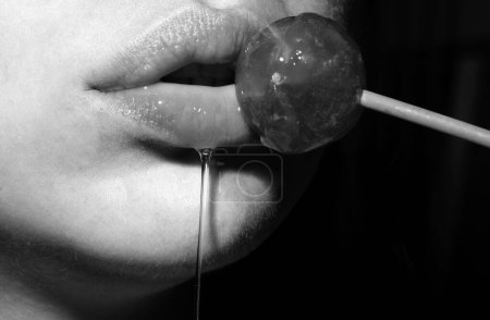 Photo for Licking candy. Lollipop model. Woman lips sucking a candy. Oral sex blow job concept. Glamor sensual model with red lips eat sweats lolly pop - Royalty Free Image