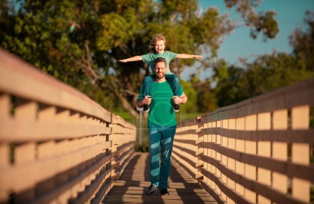 Foto de Papá y su hijo se divierten al aire libre. Padre dando paseo hijo de vuelta en el parque - Imagen libre de derechos