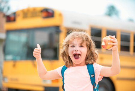 Foto de Niño subiéndose al autobús escolar. Niño con gesto positivo con la mano, pulgares arriba sonriendo y feliz. Educación en el hogar - Imagen libre de derechos