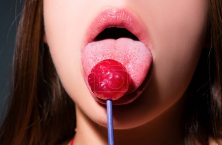 Photo for Girl with sexy mouth eating chupa chups close up. Woman lips sucking lollypop. Woman holding lollipop in mouth, close up. Red lips, sensual and sexy concept - Royalty Free Image