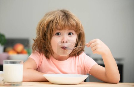 Foto de Niño pequeño caucásico comiendo sopa saludable en la cocina. Nutrición saludable para los niños. Nutrición infantil - Imagen libre de derechos