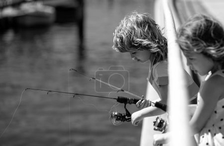 Foto de Niños amigos pescando el fin de semana. Dos jóvenes lindos niños pescando en un lago en un día soleado de verano. Amistad - Imagen libre de derechos