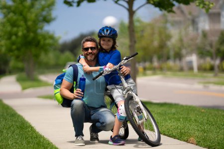 Photo for Fathers day. Father teaching son ride a bicycle. Happy loving family. Father and son hugging. Father playing with son outdoor. Father support child. Fathers love. Sporty kids - Royalty Free Image