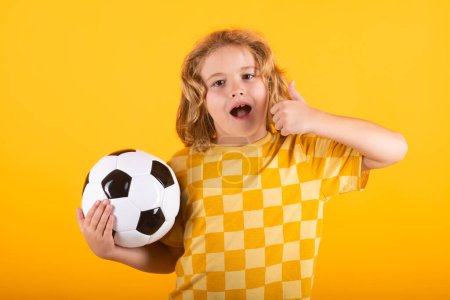 Photo for Kid holding soccer ball and smiling at camera, playing football, studio. Sport and leisure, soccer hobby for kids. Little boy holding soccer ball. Fan sport boy soccer player with football ball - Royalty Free Image