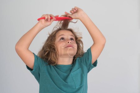 Photo for Boy brushes his hair. Little child boy combing hair, isolated background - Royalty Free Image