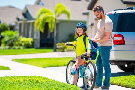 Photo for Father and son riding bike on a park. Child in safety helmet with father riding bike on summer day. Father teaching son riding on bike. Child son in bike helmet and father on bicycle. Fathers day - Royalty Free Image