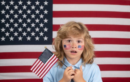 Téléchargez les photos : Kid célébration indépendance jour 4 juillet. Concept des États-Unis d'Amérique. Enfant avec drapeau américain. Jour du Souvenir. Visage d'enfant avec drapeau américain sur la joue - en image libre de droit