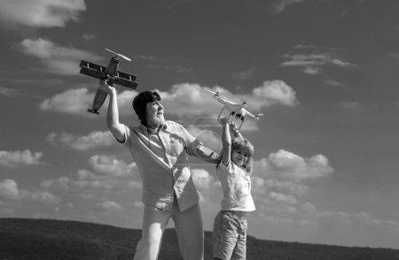 Téléchargez les photos : Petit-fils et grand-père avec avion et drone quadcopter sur fond bleu ciel et nuages - en image libre de droit