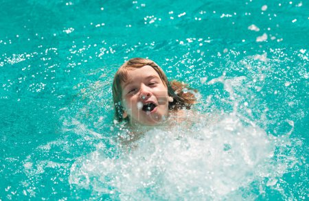 Téléchargez les photos : Enfant garçon nager dans la piscine. Versez de l'eau. Petit garçon jouant dans la piscine extérieure dans l'eau pendant les vacances d'été. Enfant apprenant à nager dans la piscine extérieure - en image libre de droit