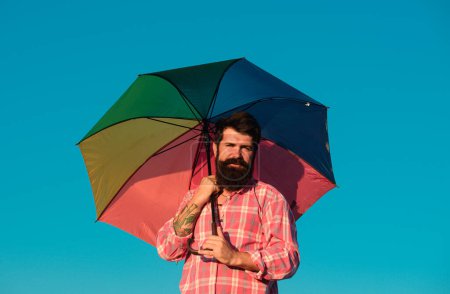 Photo for Shoulder portrait of gay man, homosexual male holding rainbow umbrella, colored in rainbow colors. LGBT movement, gay pride banner template - Royalty Free Image