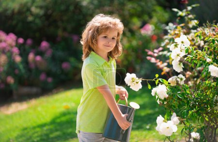 Foto de Lindo niño regando flores en el jardín en el día de verano. Niño usando regadera en el día de verano. Pequeño ayudante - Imagen libre de derechos