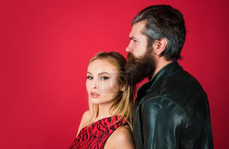 Photo for Sensual young woman and her bearded lover. Fashion couple on red - Royalty Free Image