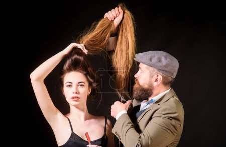 Téléchargez les photos : Coiffeur faisant coiffure, coupe de cheveux. Femme aux cheveux longs au salon de beauté. Barbier coupe les cheveux avec des ciseaux - en image libre de droit