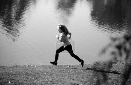 Photo for Child boy jogging in park outdoor. Sporty kid running in nature. Active healthy child boy runner jogging outdoor. Jogging helps the body to be strong - Royalty Free Image