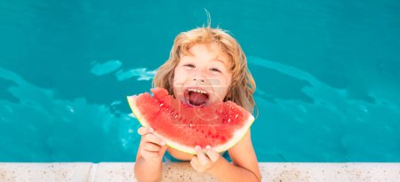 Téléchargez les photos : Enfant mangeant pastèque près de la piscine pendant les vacances d'été. Les enfants mangent des fruits à l'extérieur. Aliments sains pour les enfants. Bannière pour en-tête de conception, espace de copie - en image libre de droit