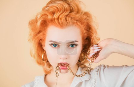 Photo for Redhead woman close up portrait with golden chain in mouth. Beautiful sexy girl - Royalty Free Image