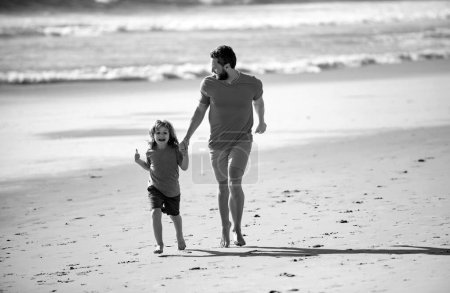 Foto de Concepto de infancia y crianza. Padre e hijo corriendo en la playa de verano - Imagen libre de derechos
