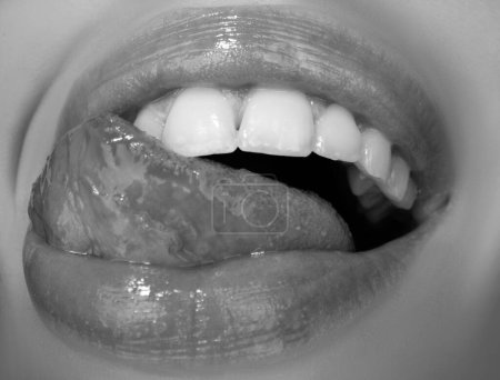 Zahnpflege, gesunde Zähne und Lächeln, weiße Zähne im Mund. Nahaufnahme eines Lächelns mit weißen gesunden Zähnen. Offener Mund, Zunge berührt die Zähne