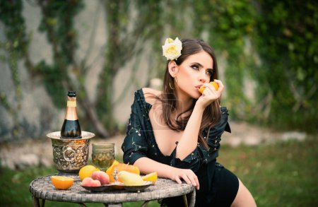 Téléchargez les photos : Portrait de mode en plein air jolie fille se détendre près du jardin d'été avec des fruits tropicaux - en image libre de droit
