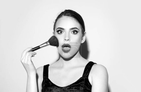 Foto de Hermosa modelo de chica sorprendida con maquillaje natural. Cepillo de polvo cosmético - Imagen libre de derechos