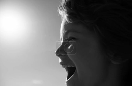 Foto de Retrato de un niño feliz riendo. Primer plano chico positivo gritando, cara de perfil - Imagen libre de derechos