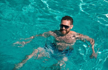 Photo for Summertime vacation at pool. Summer weekend. Handsome man in swimmingpool water. Pool spa resort - Royalty Free Image