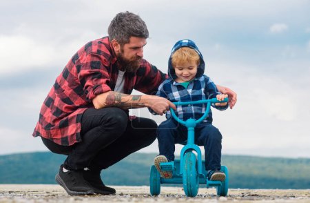 Téléchargez les photos : Père et fils vélo avec enfants vélo en plein air - en image libre de droit