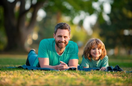 Foto de Padre con hijo relajarse en la hierba verde - Imagen libre de derechos