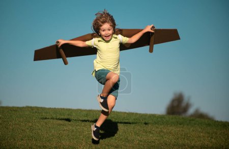 Photo for Child to be pilot. Kid with paper wings flying. Summer vacation and travel concept. Funny child boy with toy cardboard airplane wings fly on sky. Startup freedom and kids carefree concept - Royalty Free Image
