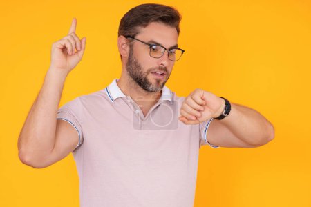 Photo for The times. Excited man In hurry pointing to watch time, impatience, deadline. Guy pointing on watch. The business time. Businessman wear glasses looks at wristwatch checks time. Time on wrist watch - Royalty Free Image