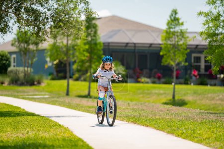 Photo for Child in safety helmet riding bike. Boy riding bike wearing a helmet outside. Child in safety helmet riding bike. Little kid boy learns to ride a bike. Kid on bicycle. Happy child in helmet riding a - Royalty Free Image