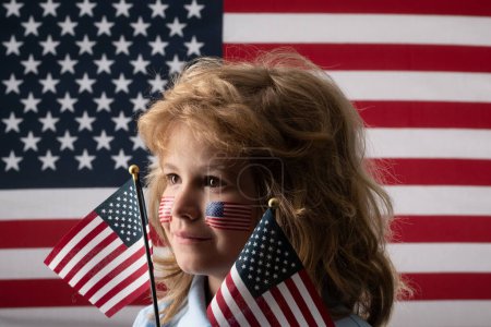 Téléchargez les photos : Kid célébration indépendance jour 4 juillet. Concept des États-Unis d'Amérique. Enfant avec drapeau américain. Jour du Souvenir. Visage drôle d'enfants avec drapeau américain sur la joue. Visage drôle d'enfants - en image libre de droit