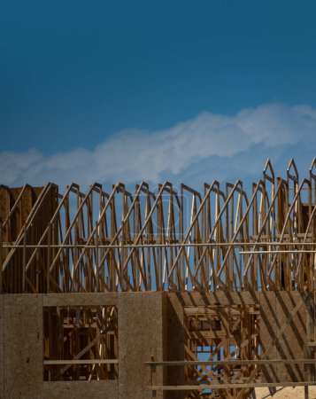 Photo for Wooden roof building. Standard timber framed building with roof trusses. Roof Frame house. The frame of the new build home. Construction site. Roof trusses constructed with construction beams timber - Royalty Free Image