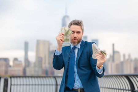 Photo for Businessman with dollars money. Excited man with dollar money on street. Rich business man in suit hold dollar cash. Businessman hold 100 dollars banknotes at city. Dollars banknote - Royalty Free Image