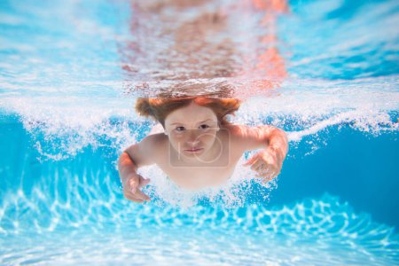 Foto de Chico submarino en la piscina. Niño lindo nadando en la piscina bajo el agua. Playa mar y agua diversión - Imagen libre de derechos