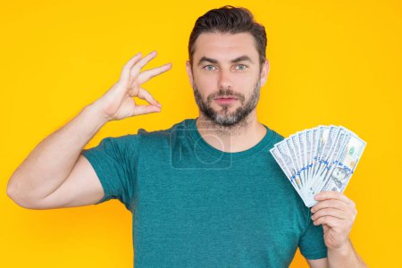 Photo for Portrait of lucky man holding cash dollar bills on yellow studio. Big luck, banner. Dollar cash money concept. Rejoices to win cash, lucky money. Man hold cash money. Financial luck and success - Royalty Free Image