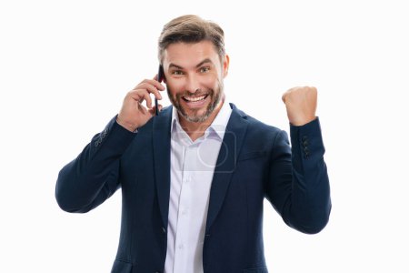 Excited business man talking on phone. Business man in suit using smart phone isolated over studio background. Portrait of cheerful guy using cell phone, browse social media on phone