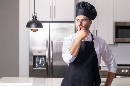 Téléchargez les photos : Portrait de chef homme dans une casquette de chef dans la cuisine. Homme portant tablier et chef uniforme et chapeau de chef. caractère kitchener, chef pour la publicité - en image libre de droit